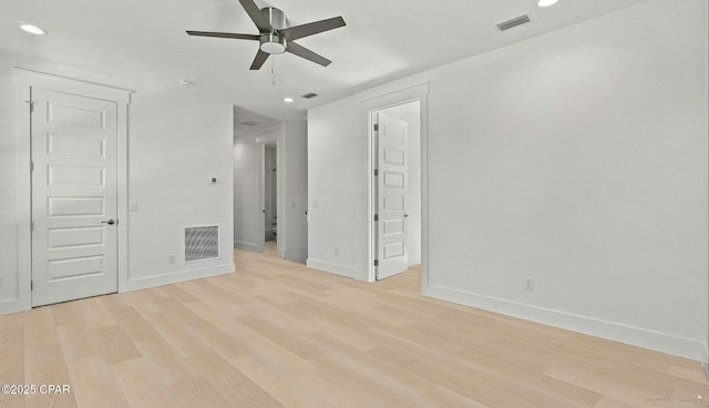 spare room featuring a ceiling fan, visible vents, and light wood finished floors