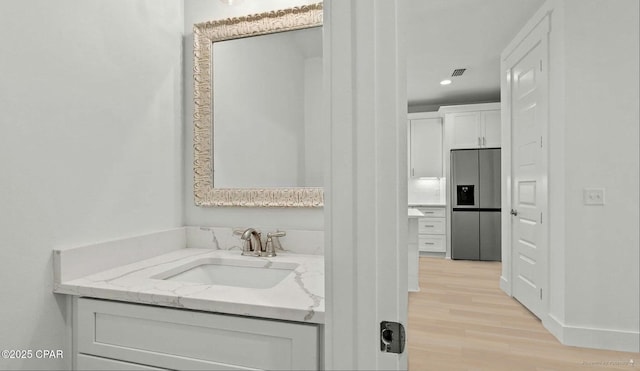 bathroom featuring visible vents, wood finished floors, recessed lighting, baseboards, and vanity