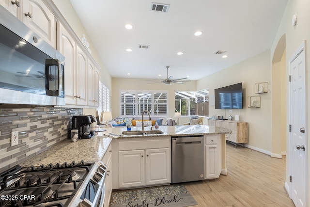 kitchen featuring a sink, visible vents, appliances with stainless steel finishes, and a peninsula