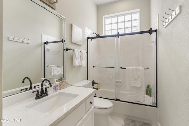 full bath featuring vanity, toilet, and bath / shower combo with glass door