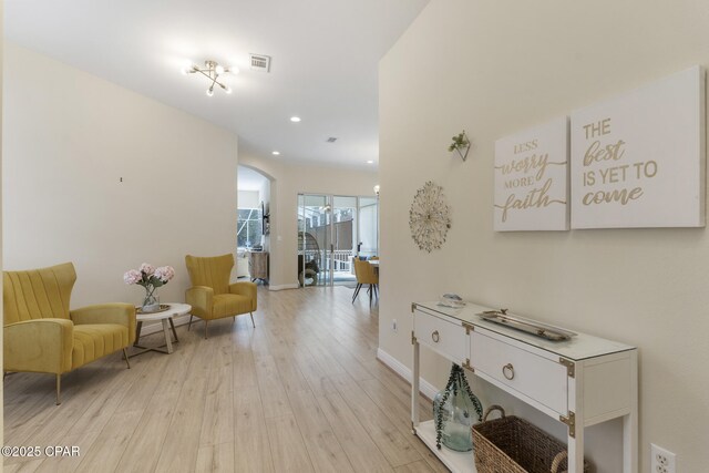 hall with visible vents, recessed lighting, light wood-type flooring, and baseboards