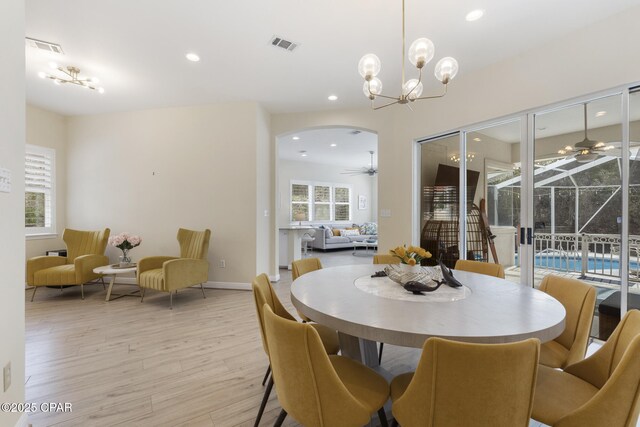 dining space with recessed lighting, visible vents, light wood-style floors, and ceiling fan with notable chandelier