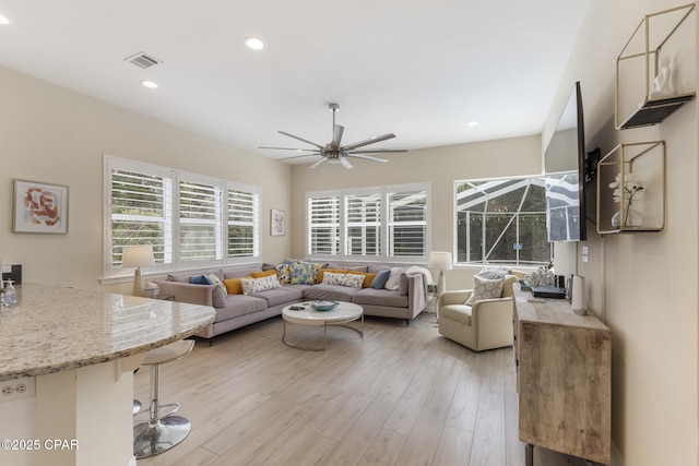 living room featuring recessed lighting, light wood-style flooring, visible vents, and ceiling fan