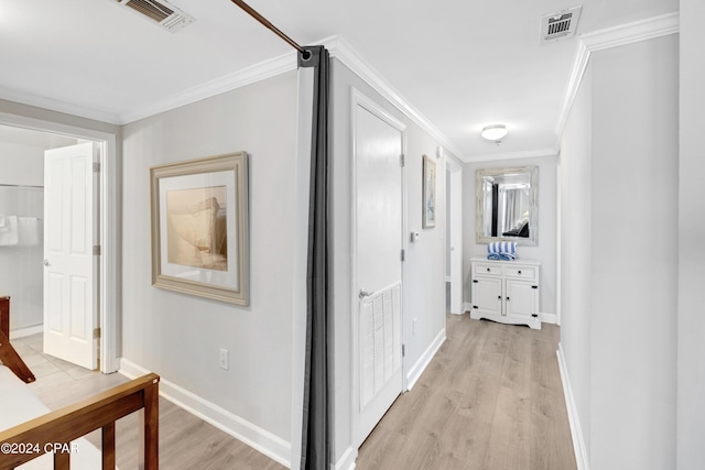 hallway featuring ornamental molding, light wood-type flooring, and visible vents