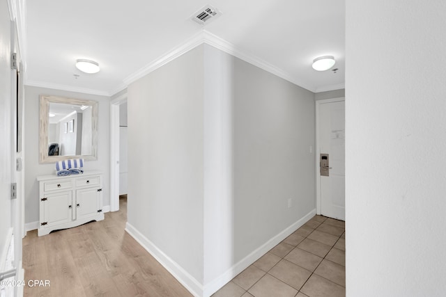 corridor with light wood-type flooring, visible vents, crown molding, and baseboards