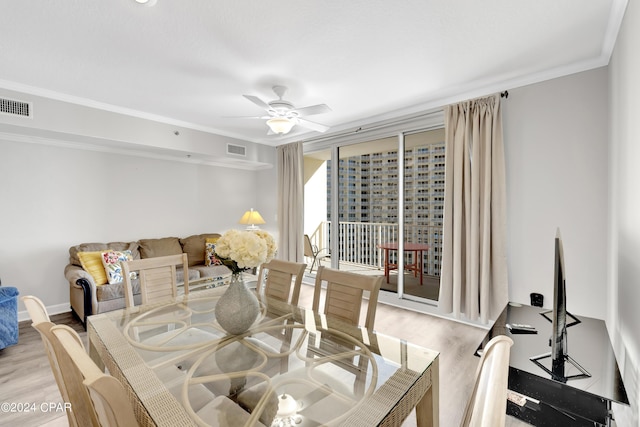 dining room featuring light wood-style floors, visible vents, ceiling fan, and crown molding