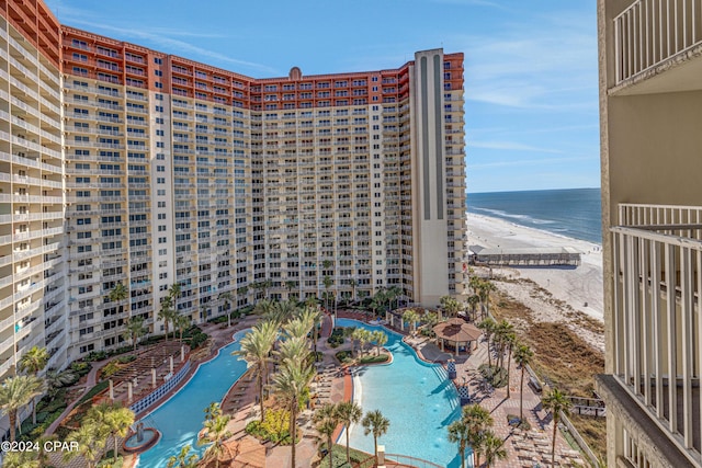 exterior space with a water view, a beach view, and a community pool