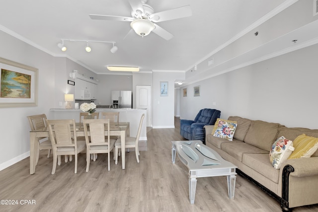 living room featuring light wood finished floors, baseboards, ceiling fan, ornamental molding, and rail lighting