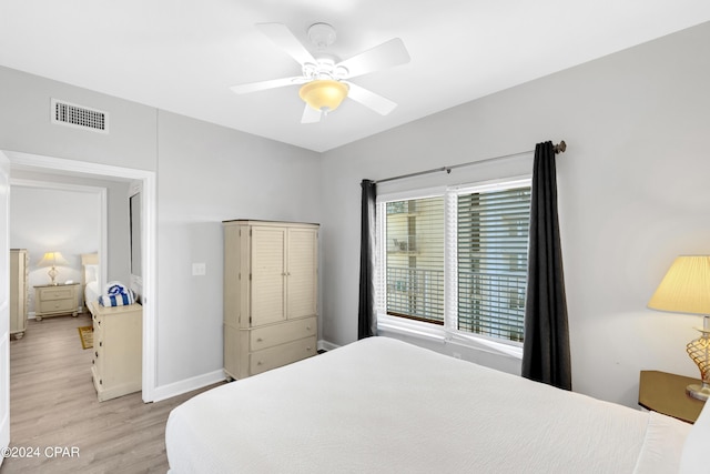 bedroom with light wood finished floors, baseboards, visible vents, and a ceiling fan