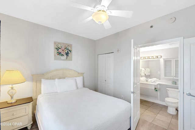 bedroom featuring light tile patterned floors, ceiling fan, a closet, and connected bathroom