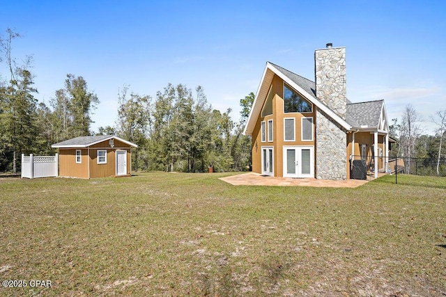 exterior space with an outbuilding, french doors, a lawn, and fence