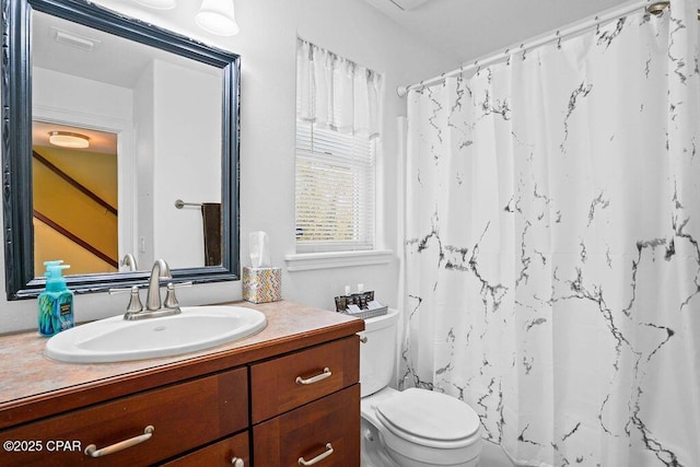 bathroom featuring a shower with curtain, visible vents, vanity, and toilet