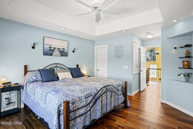 bedroom with recessed lighting, a raised ceiling, baseboards, and hardwood / wood-style floors