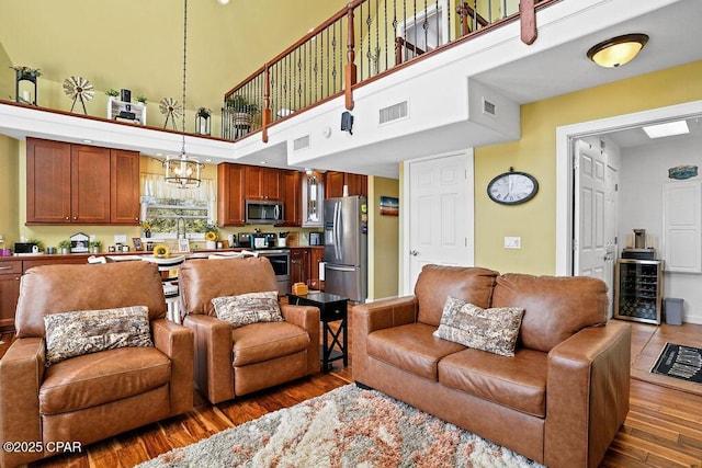 living room featuring beverage cooler, visible vents, and wood finished floors