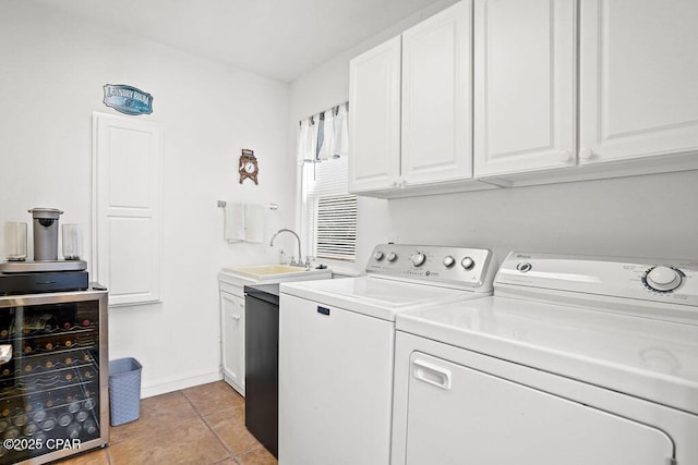 washroom with light tile patterned flooring, beverage cooler, a sink, washer and dryer, and cabinet space