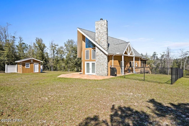 back of property featuring a yard, fence, french doors, and a patio