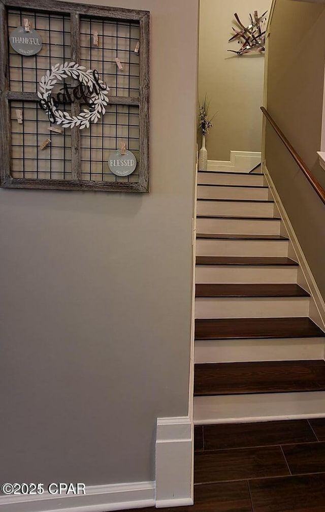 staircase with baseboards and wood finished floors
