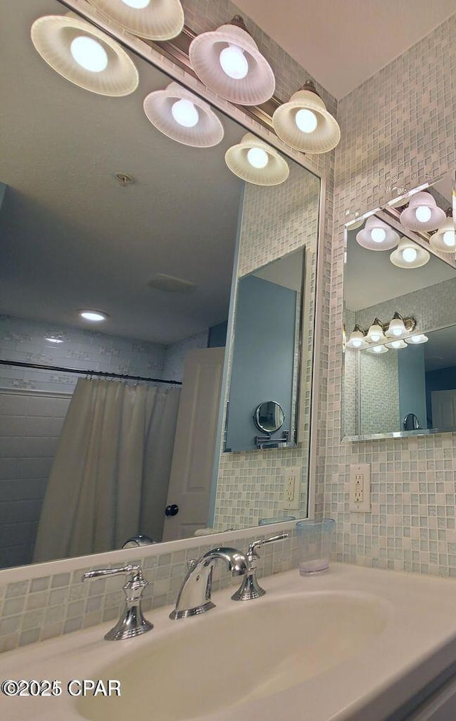 bathroom with tile walls, decorative backsplash, and a sink