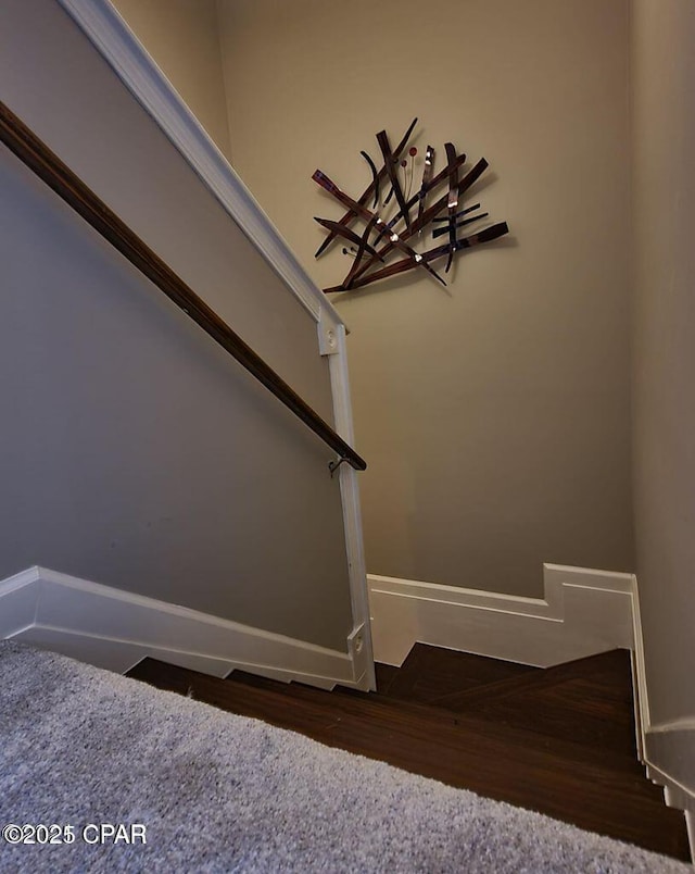 stairway featuring baseboards and wood finished floors