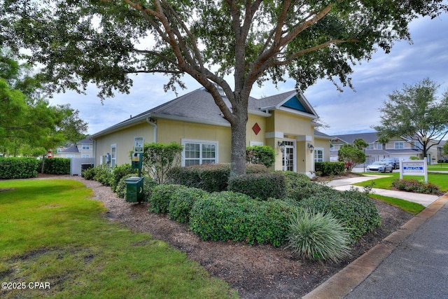 view of front facade with stucco siding and a front yard