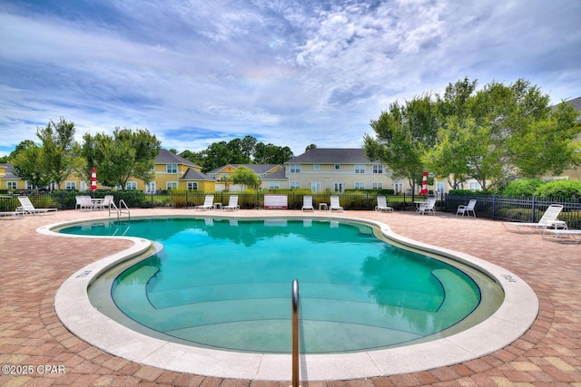 community pool featuring fence and a patio area