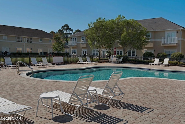 community pool featuring a patio and fence