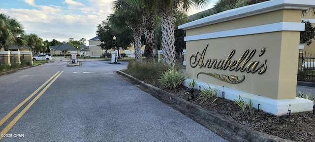 view of road featuring a residential view, a gated entry, a gate, and curbs