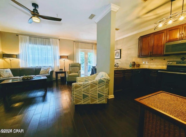 living room featuring visible vents, crown molding, dark wood-type flooring, and a ceiling fan