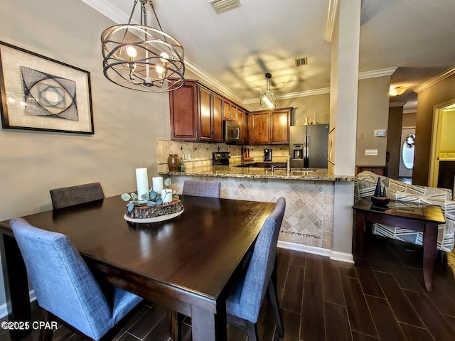 dining space with dark wood-type flooring, crown molding, visible vents, and a notable chandelier