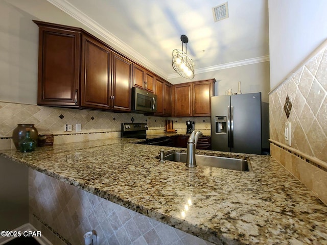 kitchen featuring a sink, light stone countertops, a peninsula, stainless steel appliances, and decorative backsplash