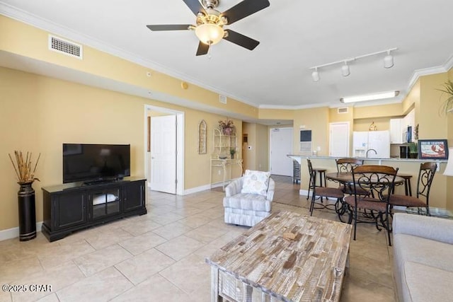 living room with rail lighting, baseboards, visible vents, and crown molding