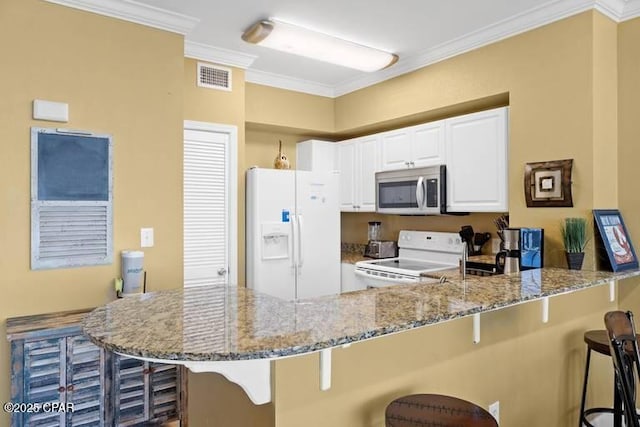 kitchen featuring light stone counters, visible vents, ornamental molding, white appliances, and a peninsula