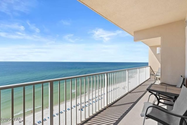 balcony featuring a water view and a beach view