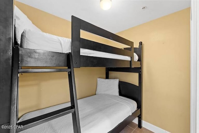 tiled bedroom featuring baseboards