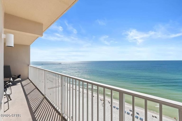 balcony featuring a beach view and a water view