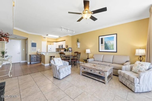 living area with light tile patterned floors, baseboards, a ceiling fan, ornamental molding, and rail lighting