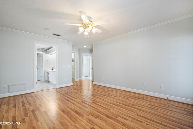 unfurnished room featuring crown molding, visible vents, light wood-style floors, a ceiling fan, and baseboards