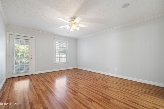 empty room with a textured ceiling, light wood-type flooring, and crown molding