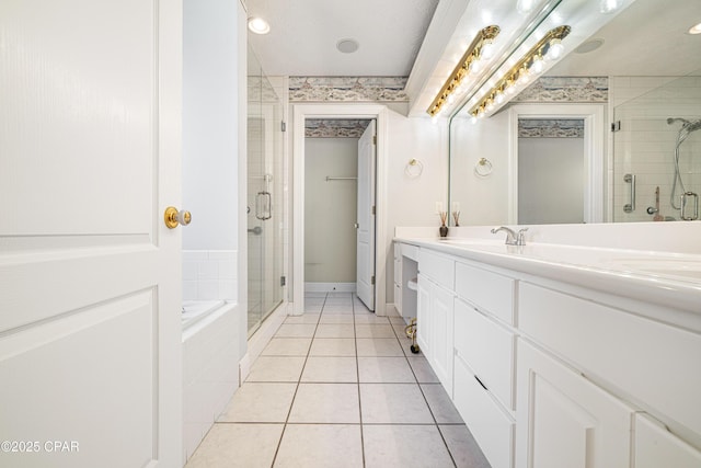 full bathroom with a garden tub, a sink, tile patterned floors, double vanity, and a stall shower