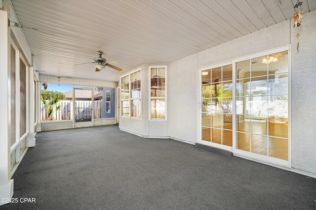 unfurnished sunroom with a ceiling fan