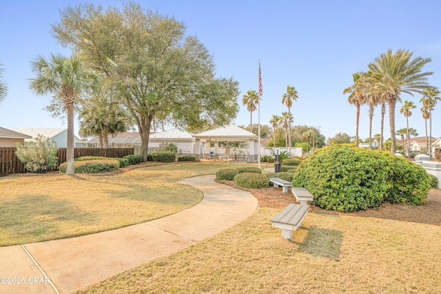 view of community featuring a yard, fence, and a gazebo