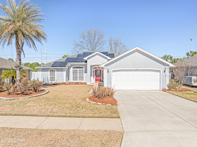 view of front of property with a garage, driveway, roof mounted solar panels, a front lawn, and stucco siding