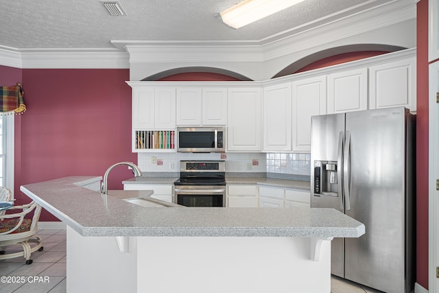 kitchen featuring appliances with stainless steel finishes, light tile patterned flooring, visible vents, and white cabinetry