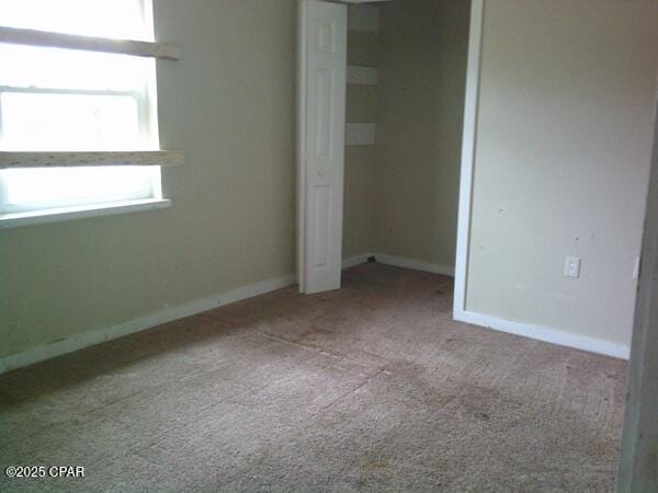 unfurnished bedroom with a closet, baseboards, and carpet