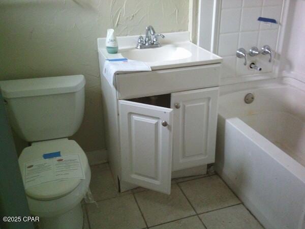 full bath featuring tile patterned flooring, vanity, toilet, and a bath