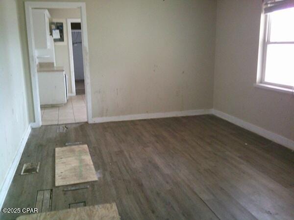 empty room with wood finished floors and baseboards