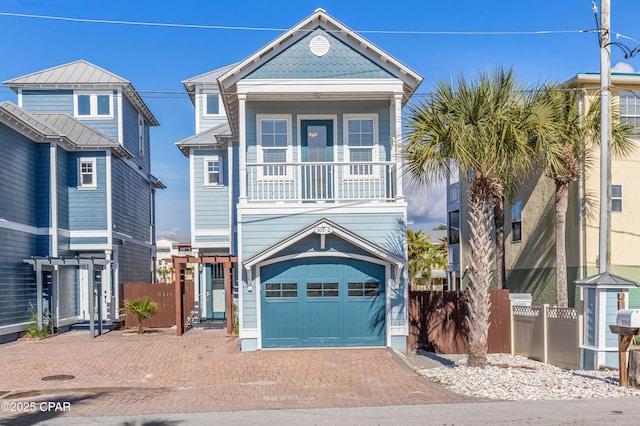 raised beach house with a garage, decorative driveway, and fence