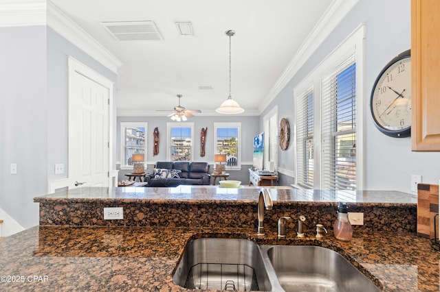 kitchen with ceiling fan, crown molding, a sink, visible vents, and pendant lighting