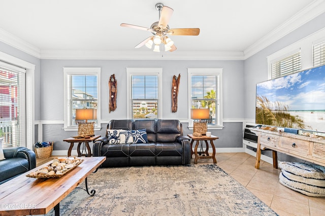 living room with tile patterned flooring, ornamental molding, a ceiling fan, and wainscoting