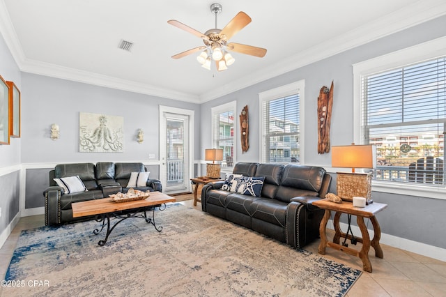 tiled living area featuring ornamental molding, a wealth of natural light, visible vents, and ceiling fan